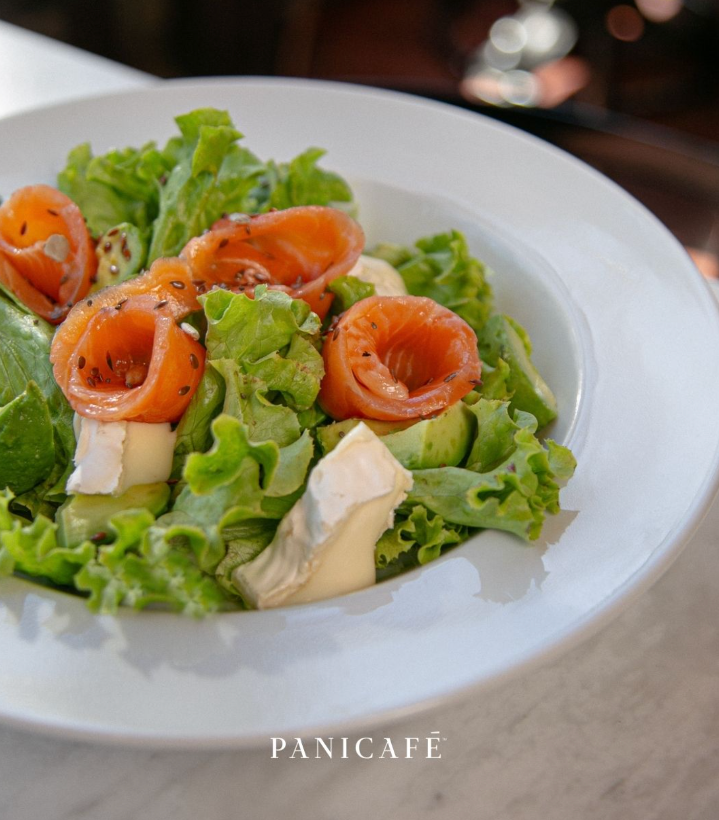 Ensalada Panicafé con salmón, hojas verdes, palta y queso