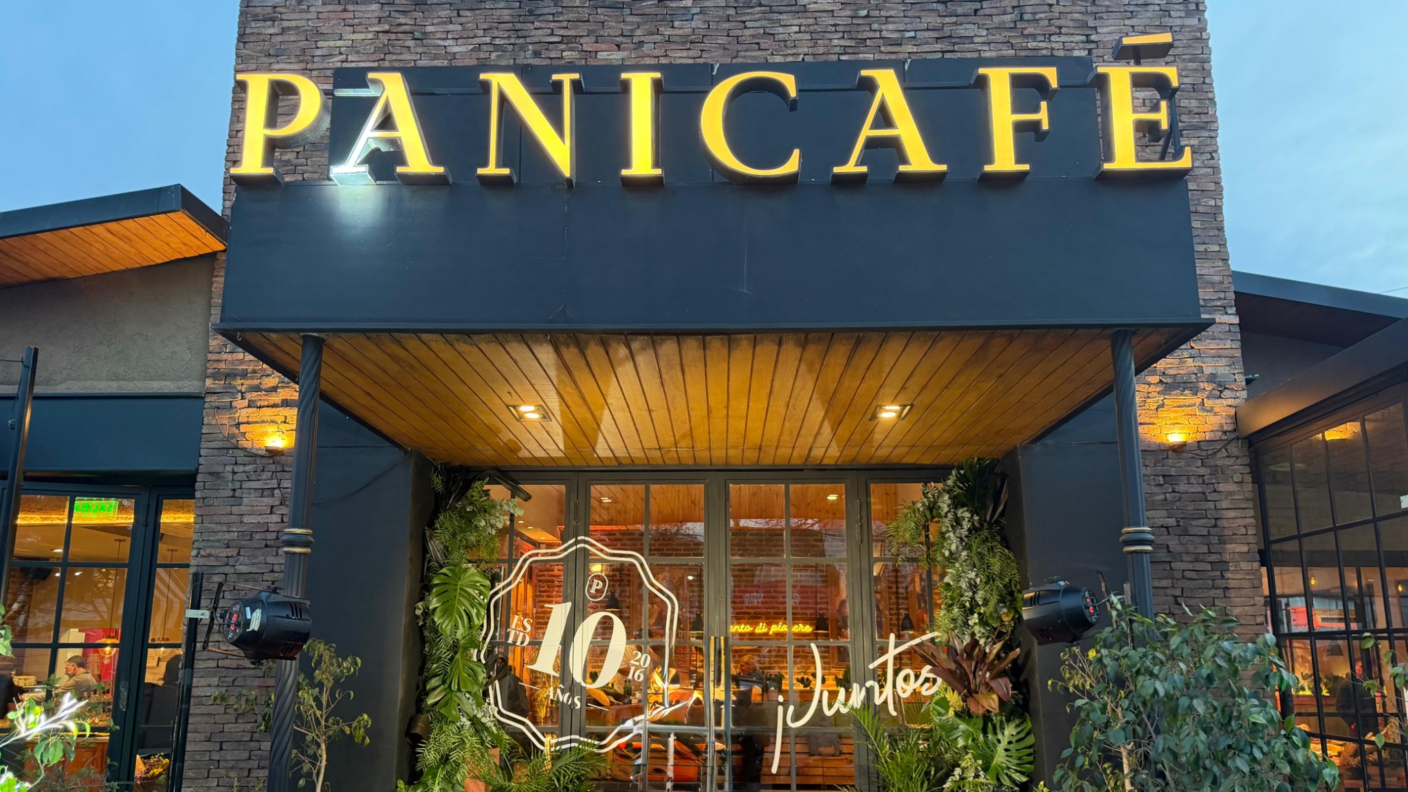 Frente del local Panicafé iluminado de noche